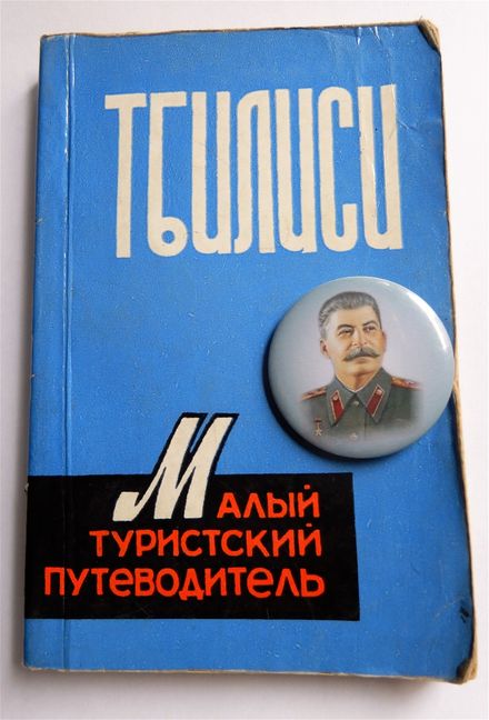 A 1978 soviet tourist guide of Tbilisi and a Stalin badge