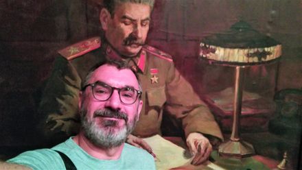 A painting of Stalin sitting behind his desk.  The 