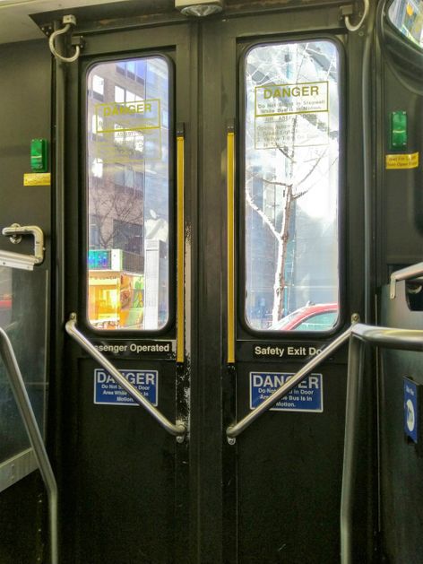 To get off the bus, wait till the green lights go on and push the yellow bars open.