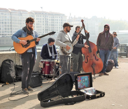 A group of musicians at the right bank of Saone River, in front of the Palais de Bondy.