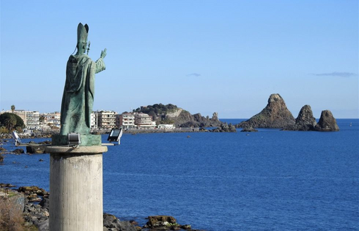 The Statua Commemorativa San Mauro Abate overlooking Isole dei Ciclopi.