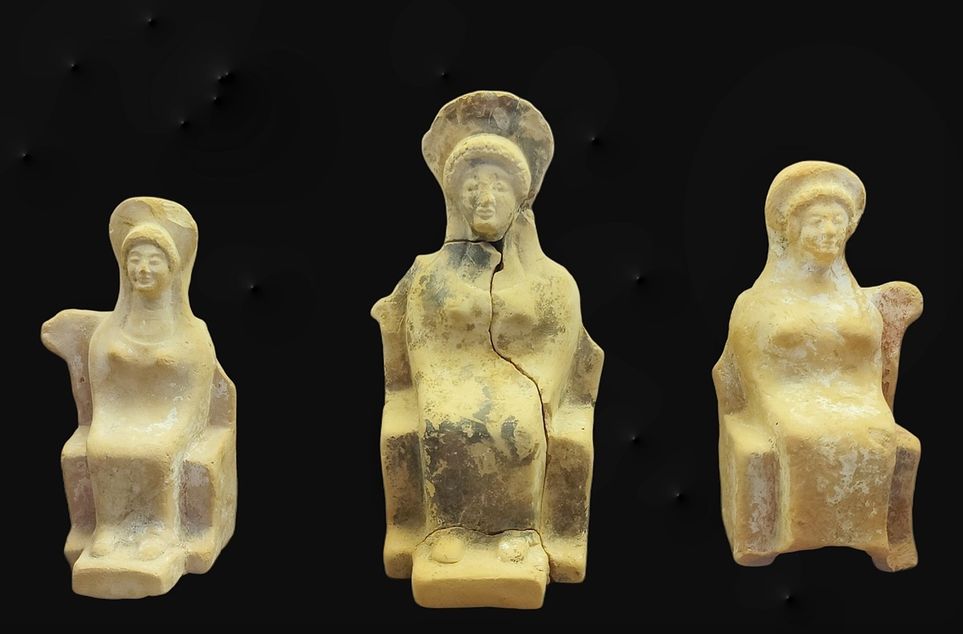 THE TANAGRA FIGURINES  During the 4th century B.C. the terracotta female figurines usually depict statue types showing the great in fluence of big sculpture. The majority of the female figurines of this period from the sanctuary belong to the type of the so-called ‘Tanagra' figurines.  The figures wear multi-folded chiton and himation tightly wrapped around the body. They were coated with a liquid white slip and were richly decorated. The arrangement of their body axis varies greatly and their hair is usually drawn back in a chignon.  They are dated from the 2nd half of the 4th century BC until the end of the 3rd century BC.