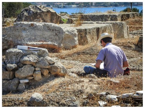 An archeologist working inside of what used to be the temple of Poseidon.